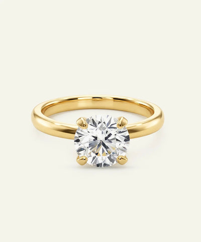Classic round diamond solitaire ring, yellow gold four-prong setting.
