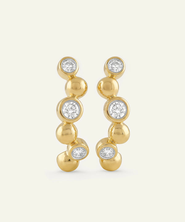 Gold earrings with clear gemstones on a white background