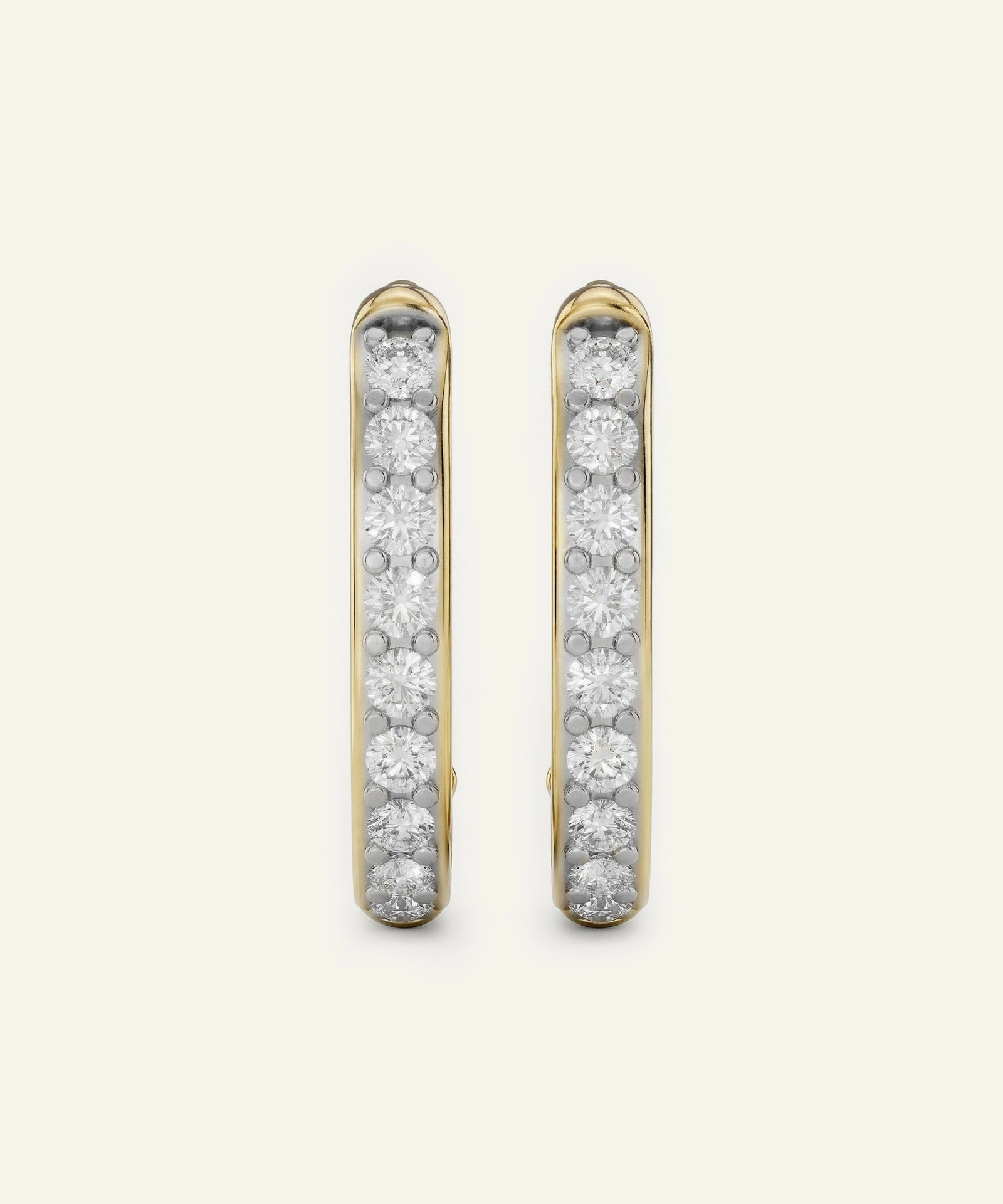 Gold hoop earrings with embedded diamonds on a light gray background