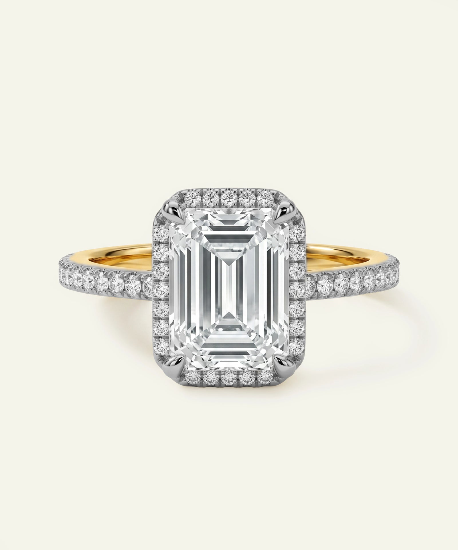Diamond ring with emerald-cut center stone and gold band on a white background