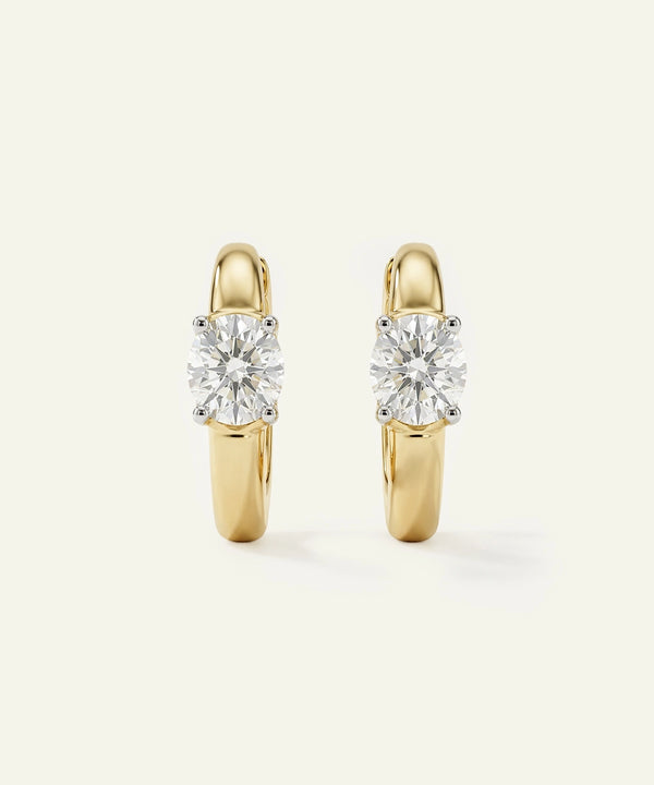 Gold hoop earrings with clear gemstones on a white background