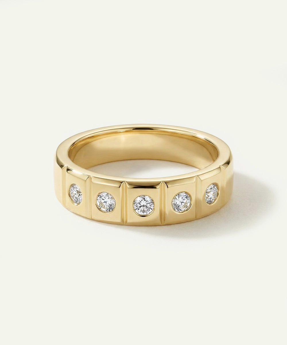 Gold ring with embedded diamonds on a light gray background