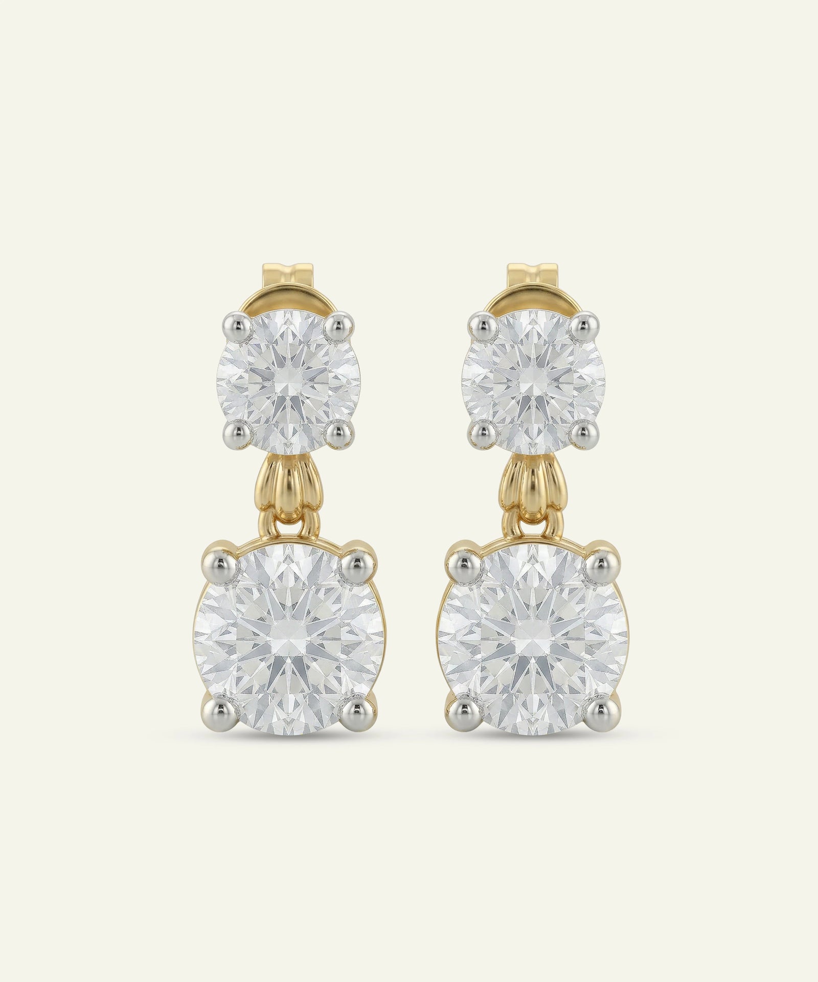Gold earrings with clear gemstones on a white background