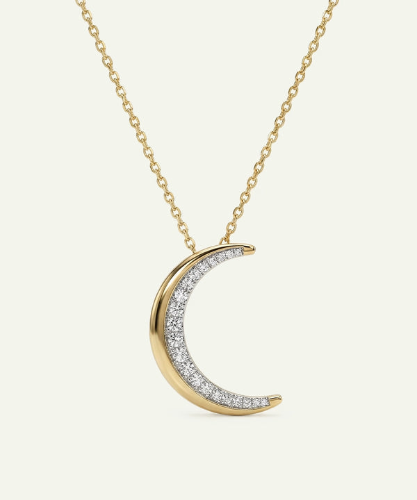 Gold and diamond crescent moon necklace on a white background