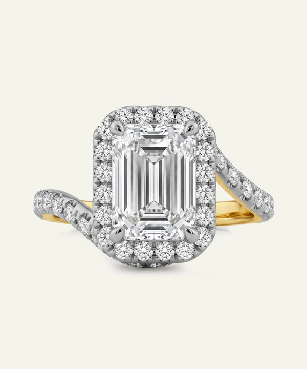 Diamond ring with emerald-cut center stone and halo on a white background