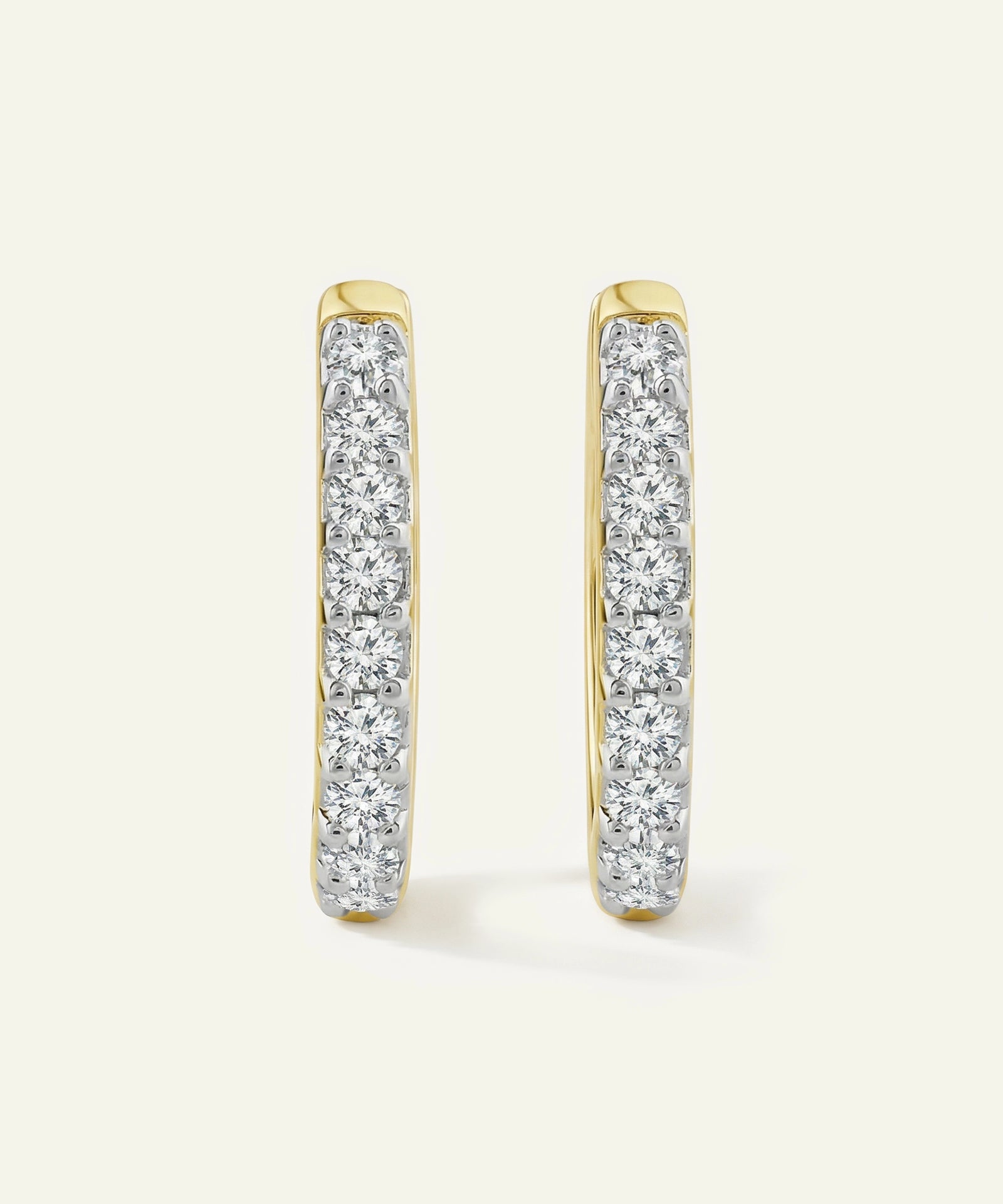 Gold hoop earrings with clear gemstones on a white background