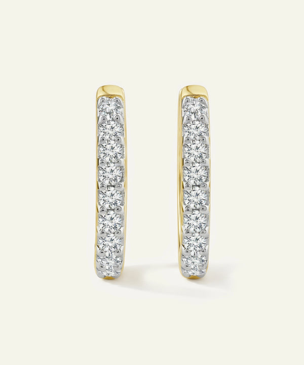 Gold hoop earrings with clear gemstones on a white background