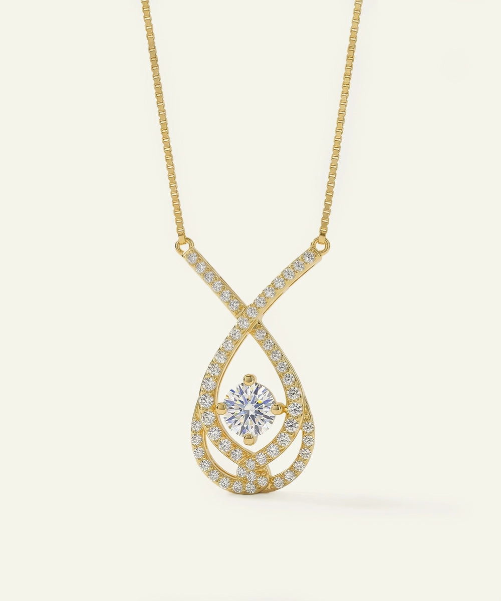 Gold necklace with a diamond pendant on a light beige background