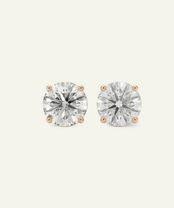 Pair of diamond stud earrings on a light gray background