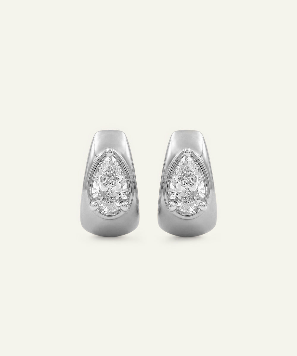 Pair of silver earrings with pear-shaped gemstones on a white background