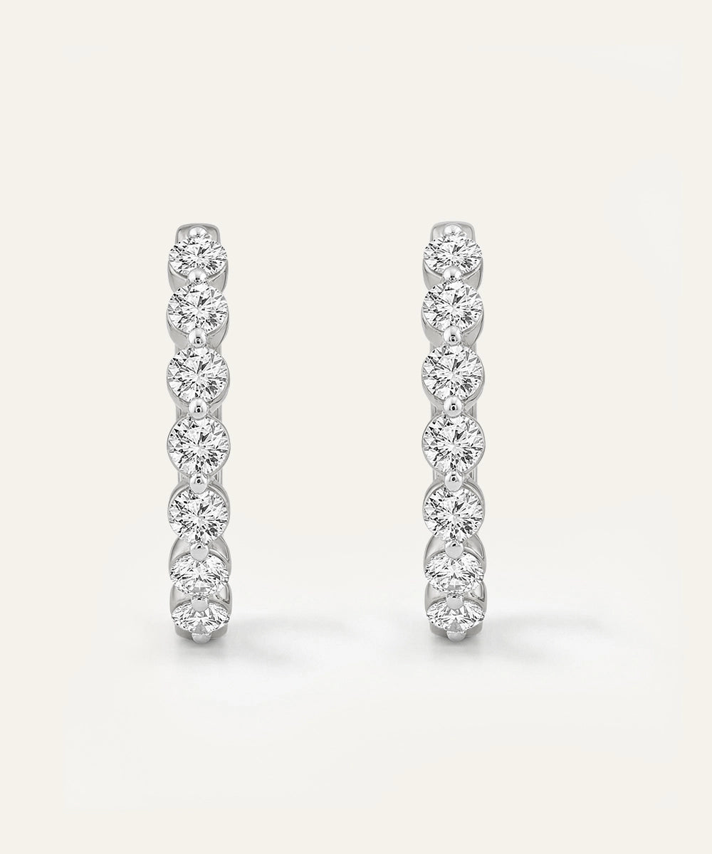 Pair of diamond earrings on a light gray background