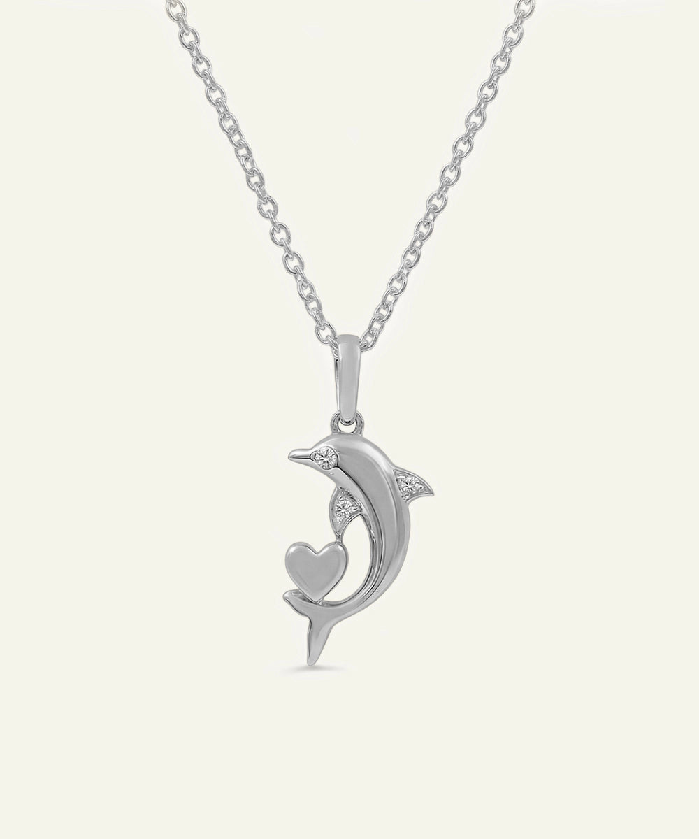 Silver pendant shaped like a dolphin with a heart on a white background