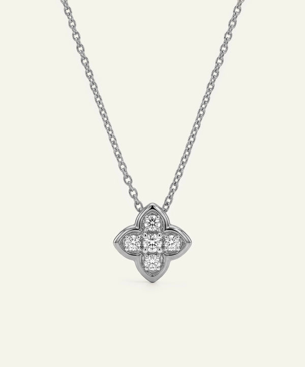 Silver necklace with a clover-shaped pendant on a white background