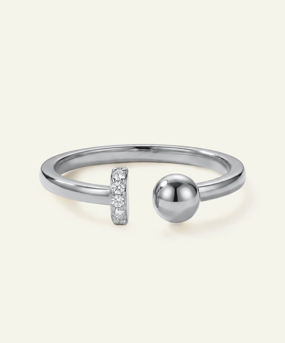 Silver ring with a spherical design and small diamond accents on a light gray background