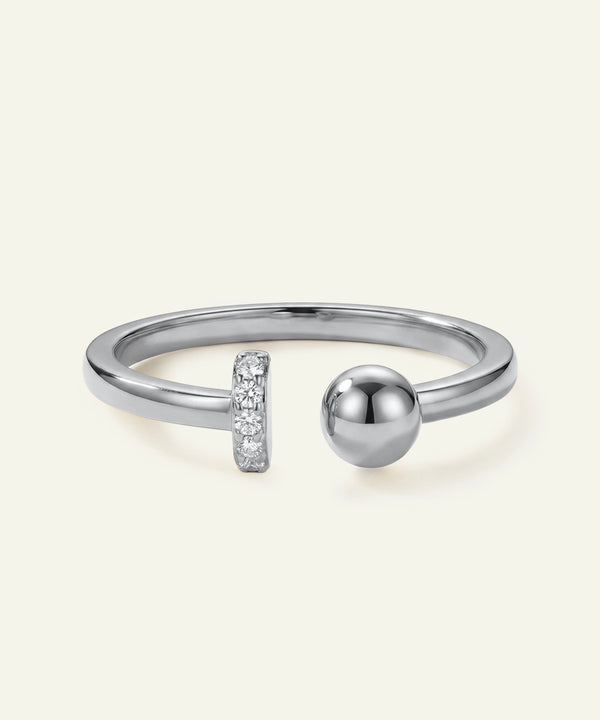 Silver ring with a spherical design and small diamond accents on a light gray background