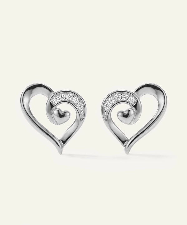 Pair of silver heart-shaped earrings with embedded stones on a white background