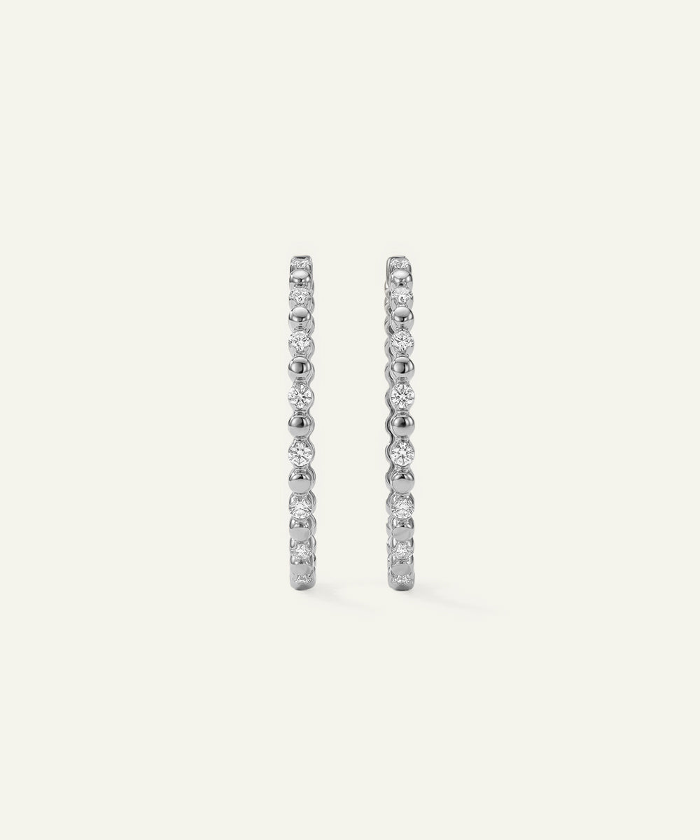 Pair of diamond hoop earrings on a light gray background
