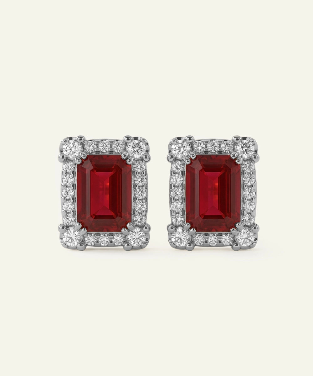 Pair of red gemstone earrings with silver accents on a white background