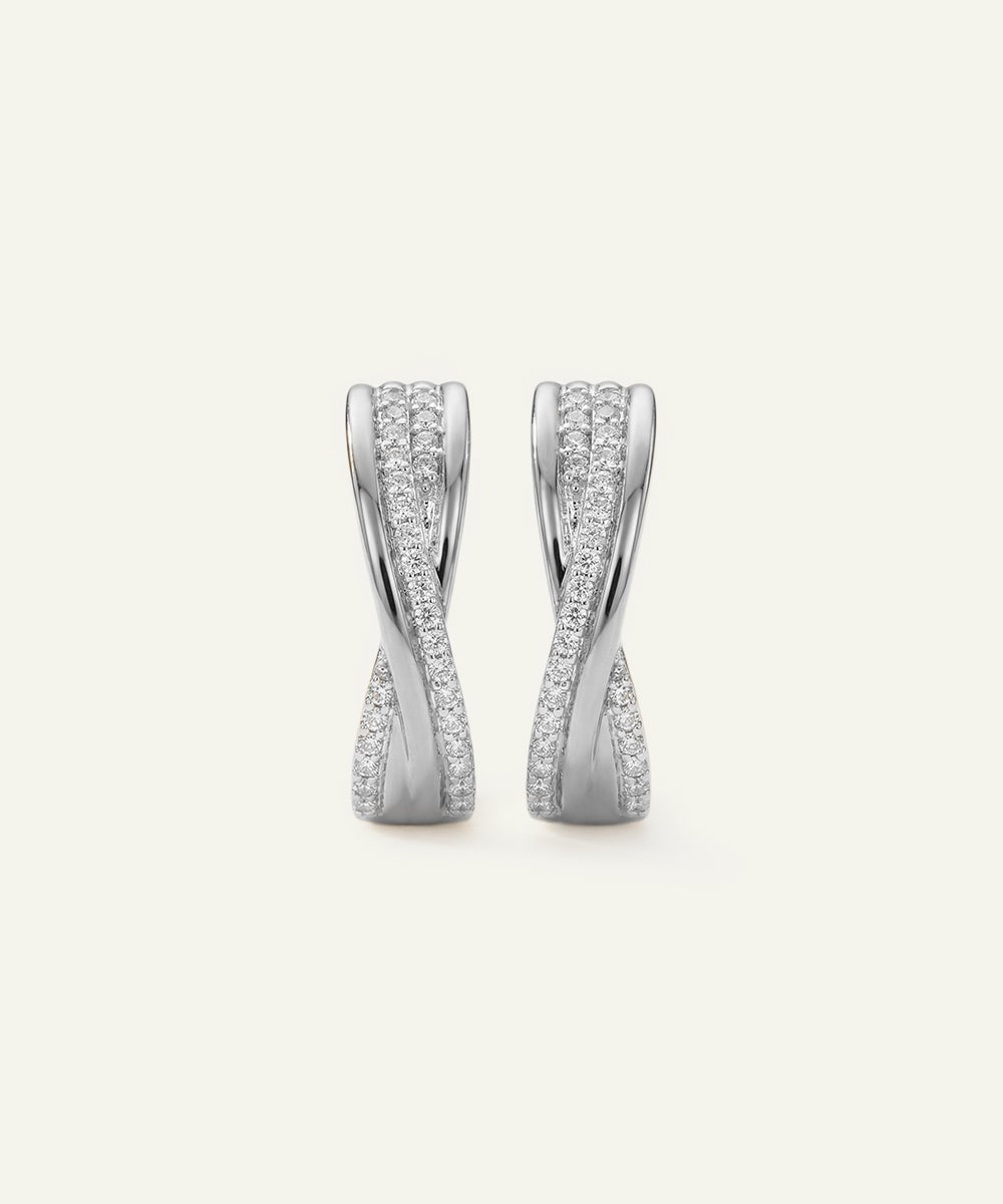 Pair of silver earrings with diamond accents on a light gray background