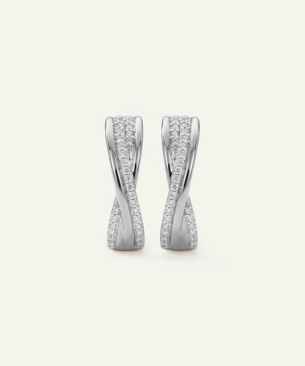 Pair of silver earrings with diamond accents on a light gray background
