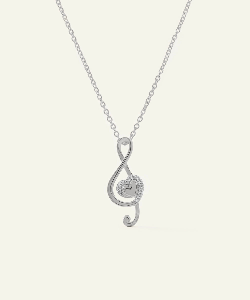 Silver treble clef necklace on a white background