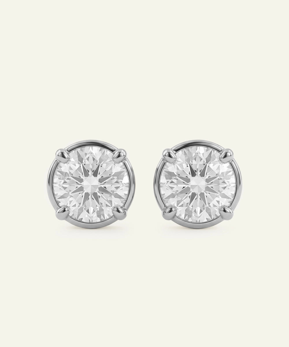 Pair of diamond stud earrings on a light gray background