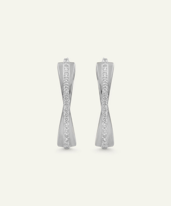 Pair of silver earrings with gemstones on a light gray background