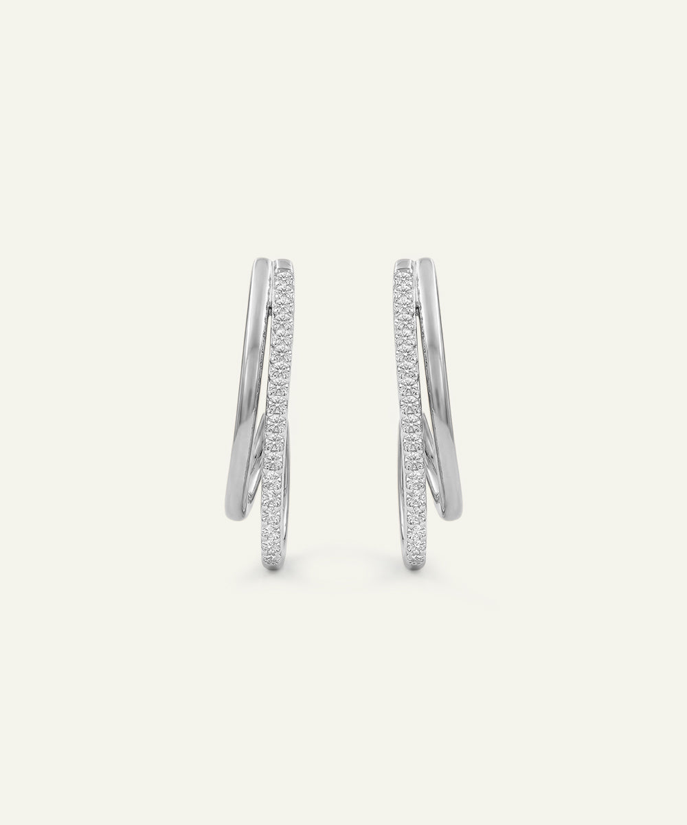 Pair of silver hoop earrings with embedded stones on a light gray background