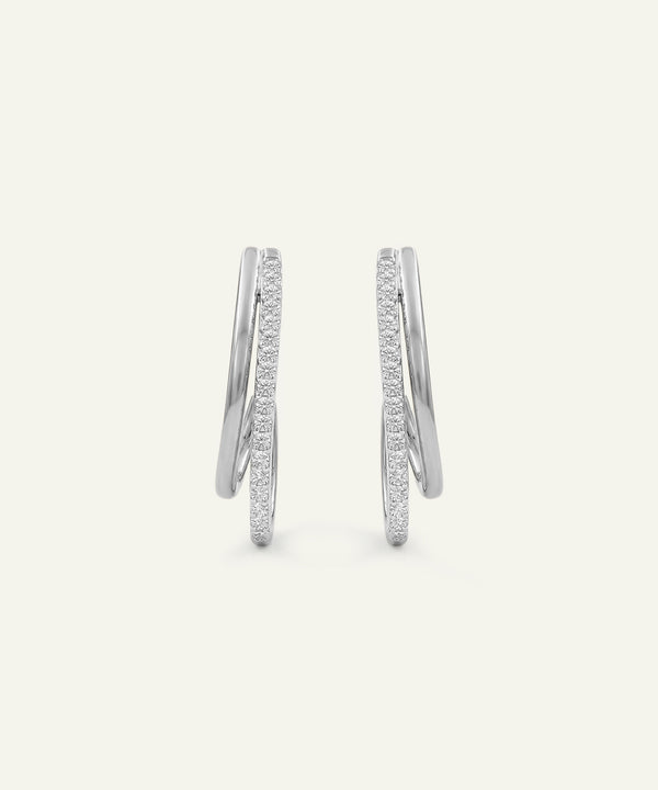 Pair of silver hoop earrings with embedded stones on a light gray background