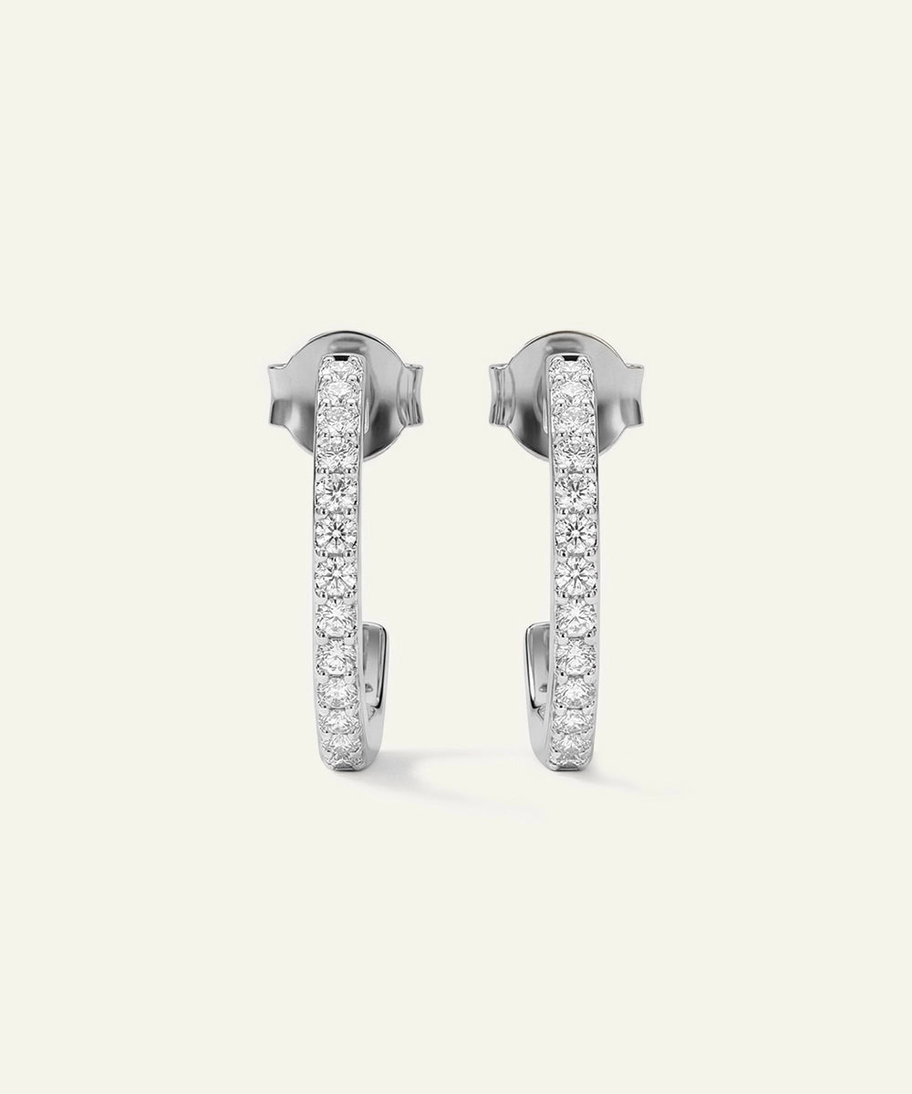 Pair of silver hoop earrings with embedded stones on a light gray background