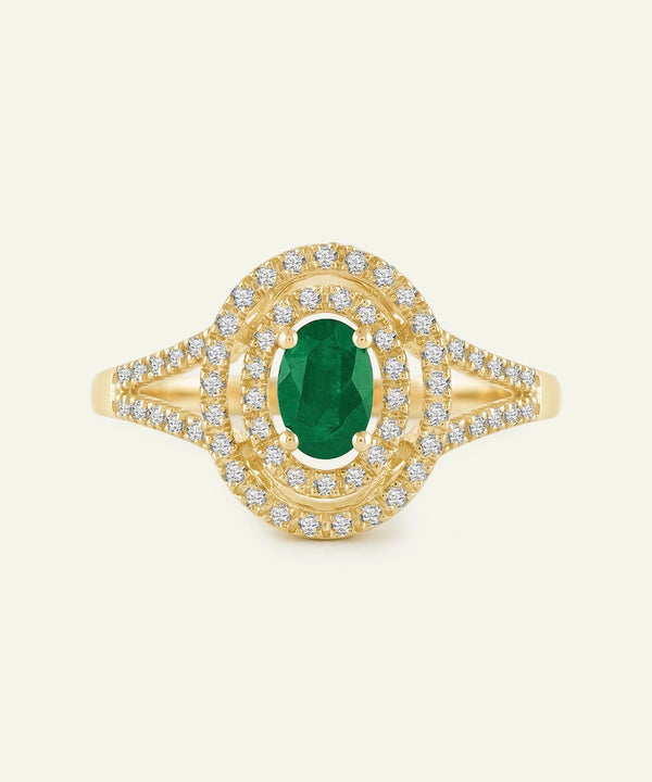 Gold ring with a green gemstone and diamond accents on a white background