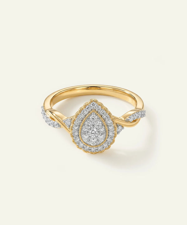 Gold ring with diamond teardrop design on a light background