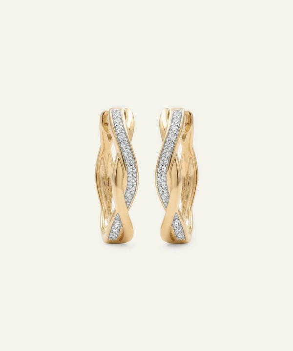 Gold hoop earrings with diamond accents on a light beige background