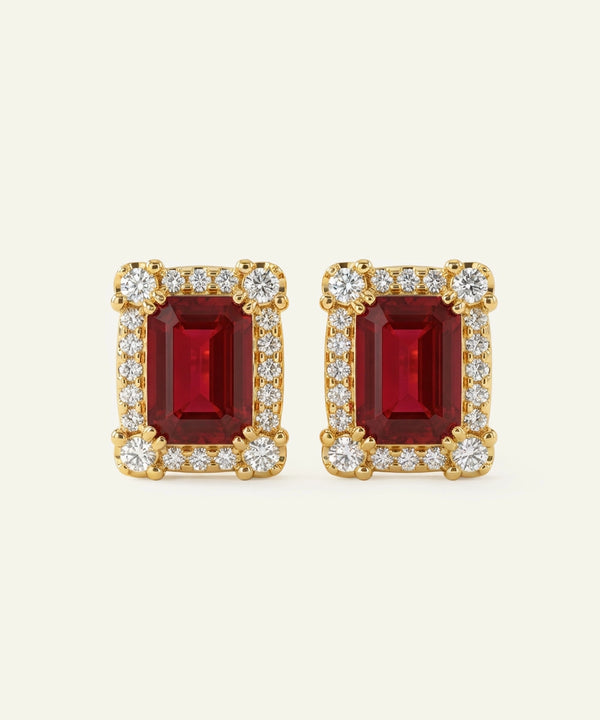 Pair of gold earrings with red gemstones on a white background