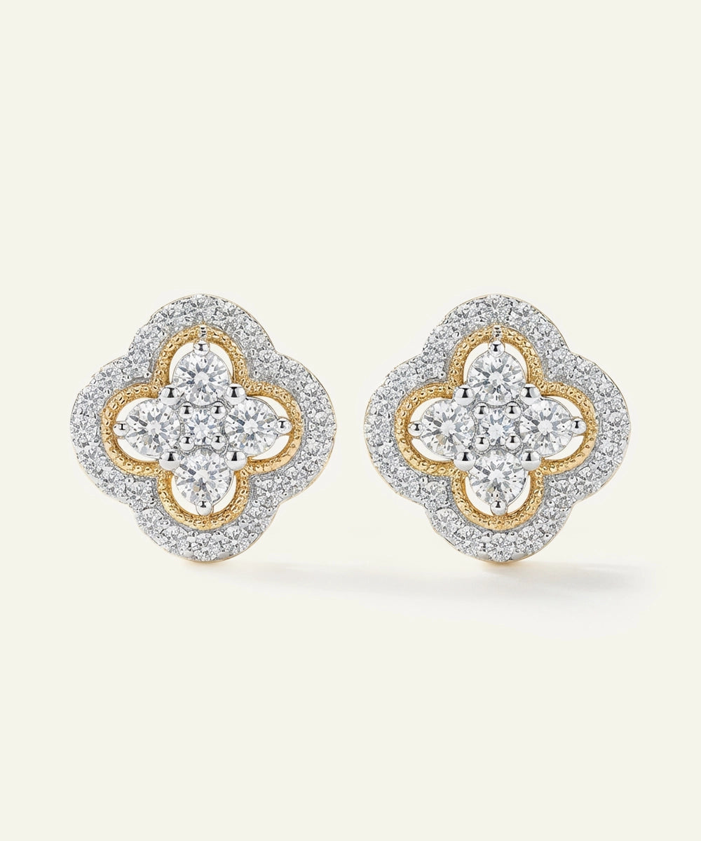 Pair of diamond earrings with gold and silver design on a light beige background