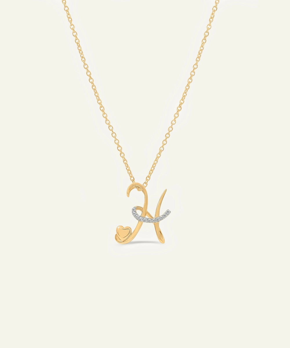 Gold necklace with a letter 'K' pendant on a light gray background