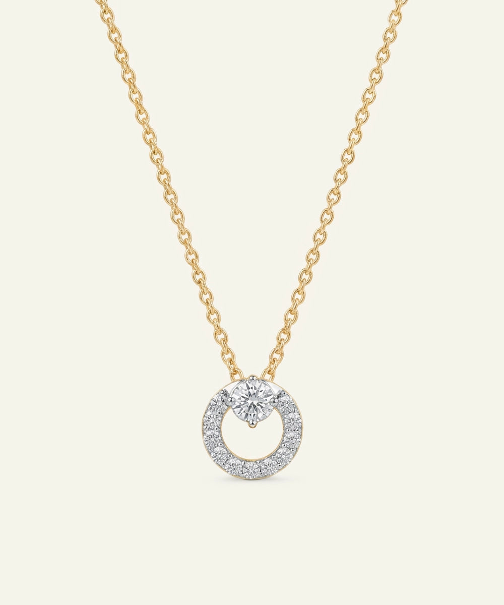 Gold necklace with a diamond pendant on a light beige background