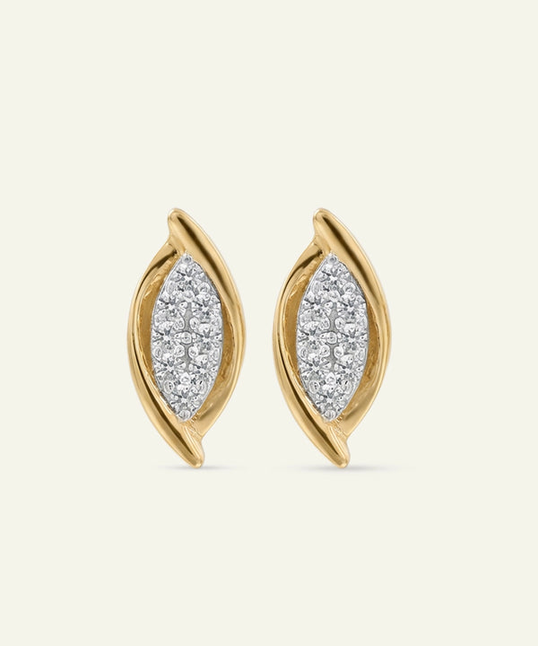 Gold earrings with diamond-like stones on a beige background