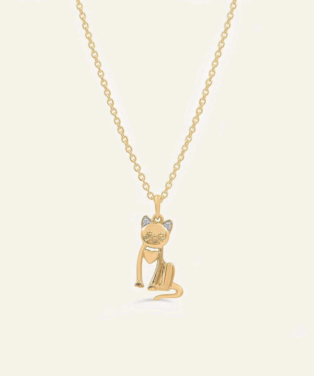 Gold cat-shaped pendant necklace on a light beige background