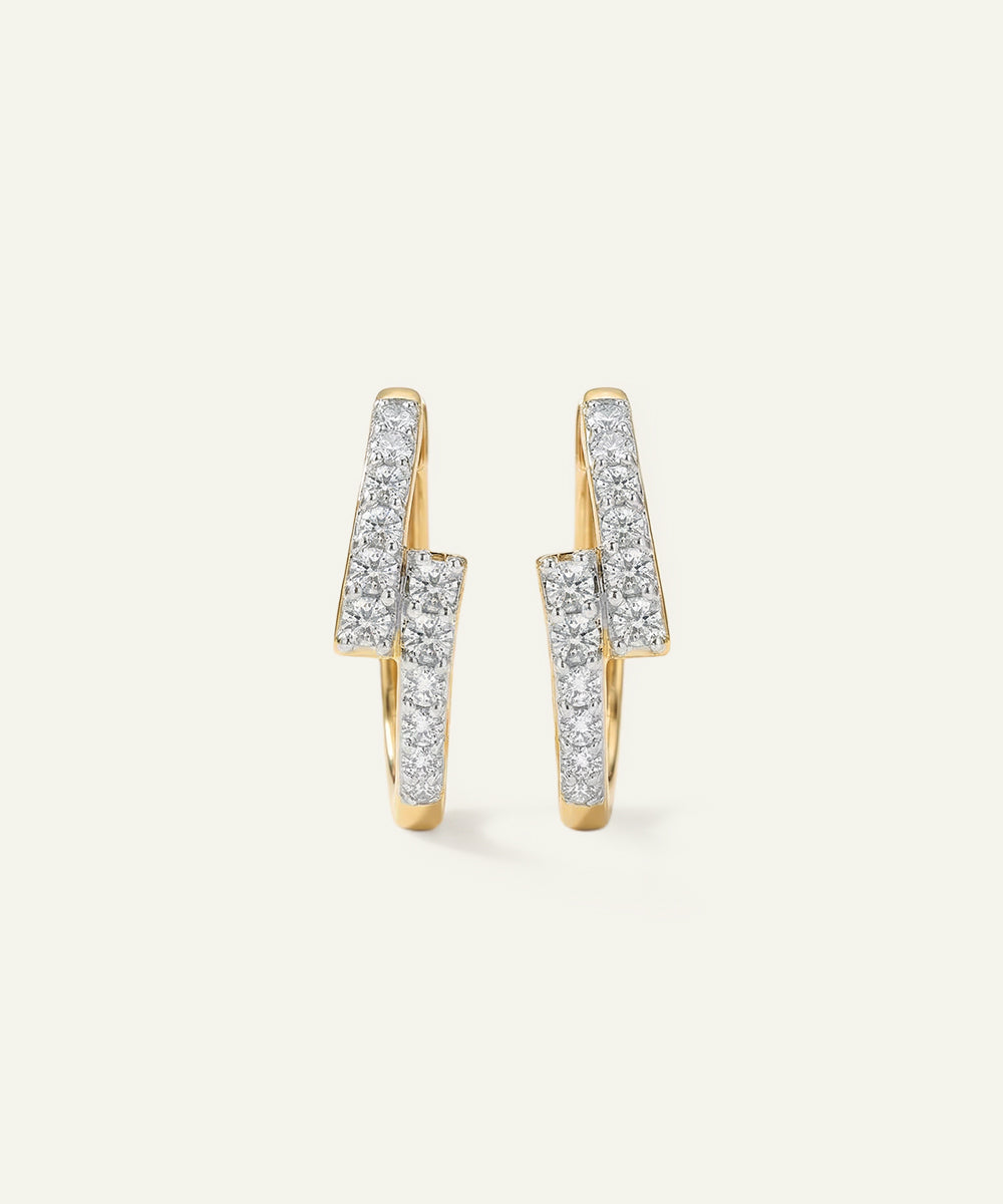 Pair of gold earrings with diamond accents on a light gray background
