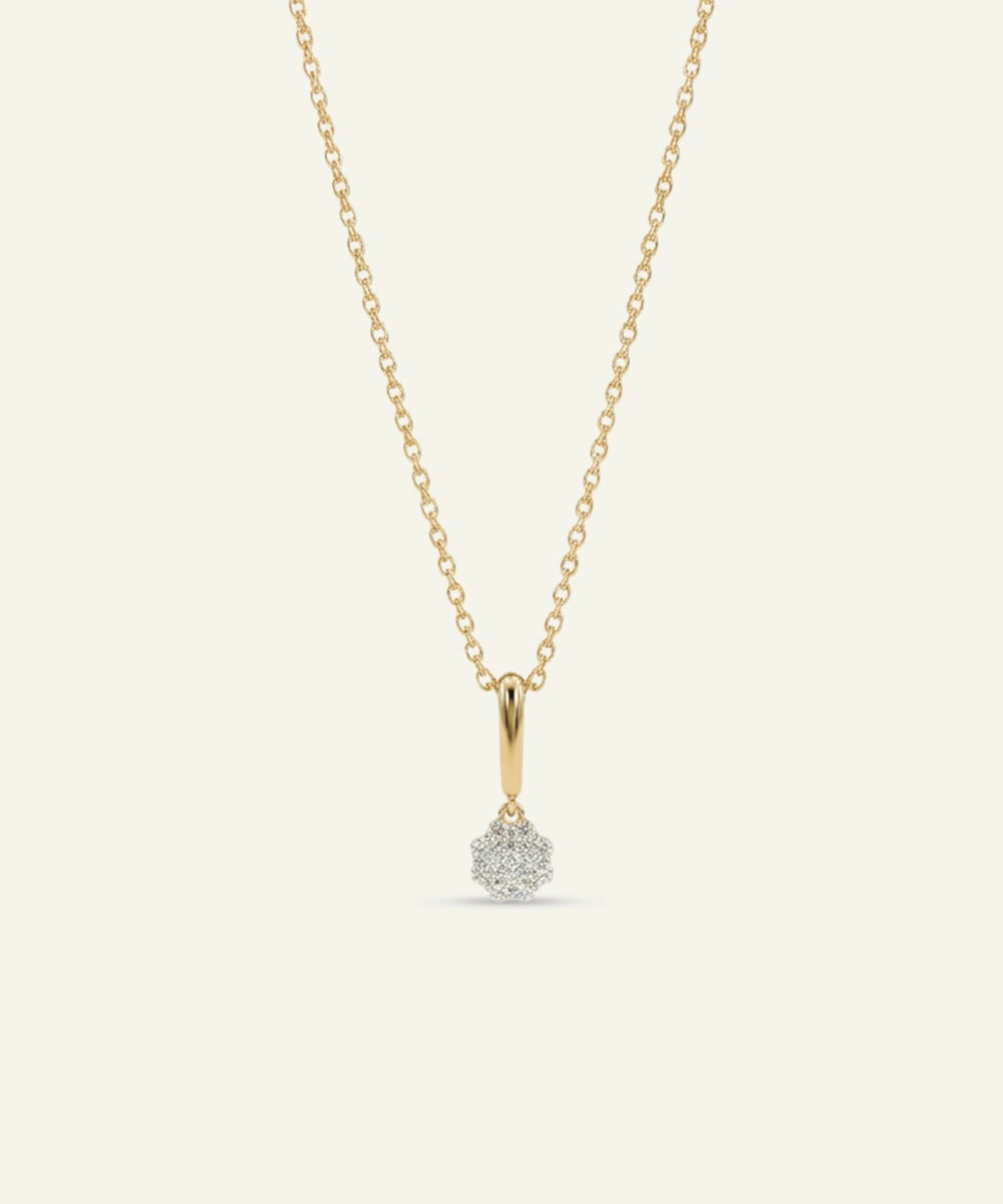 Gold necklace with a small diamond pendant on a light gray background