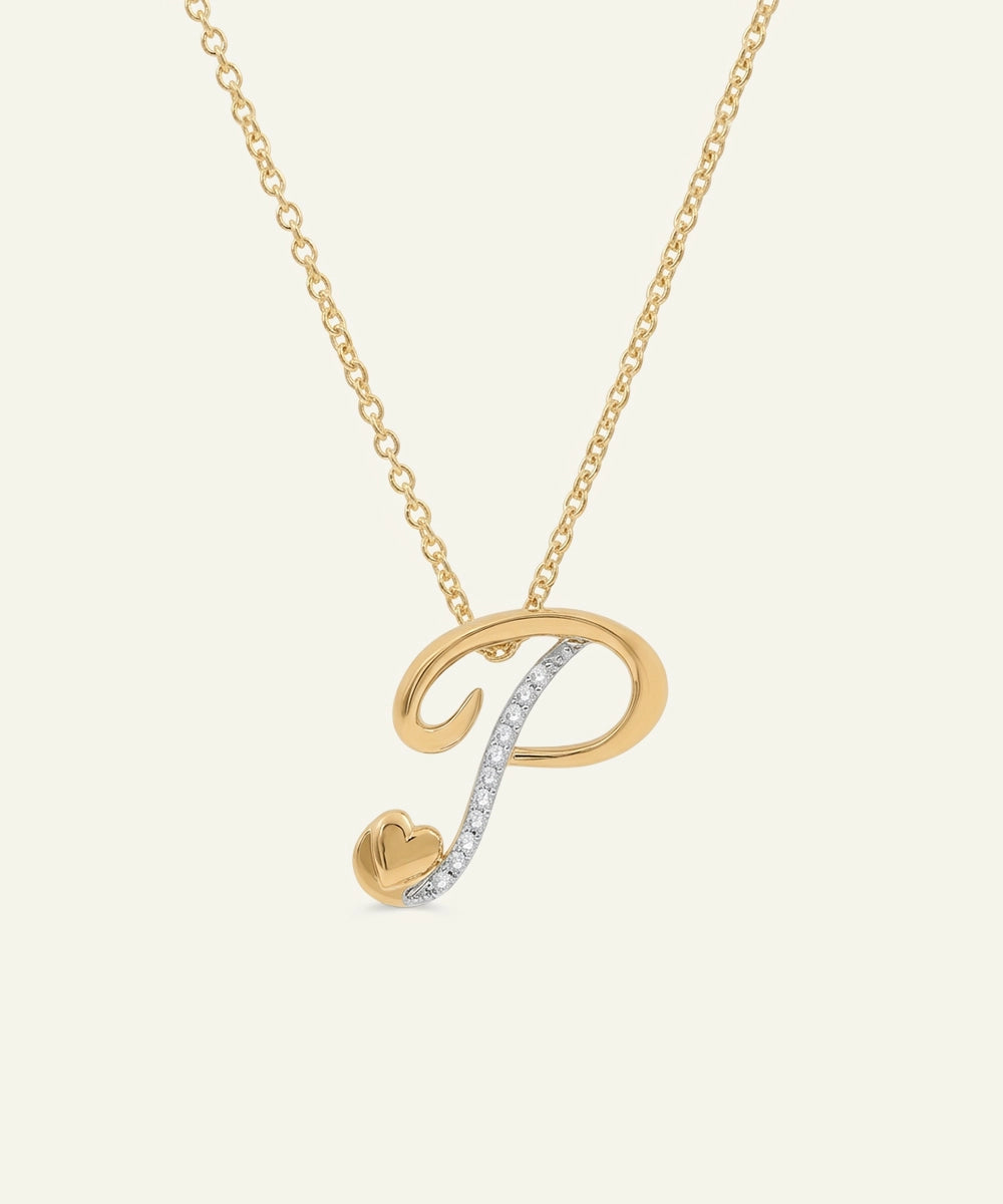 Gold and silver necklace with a heart pendant on a light beige background
