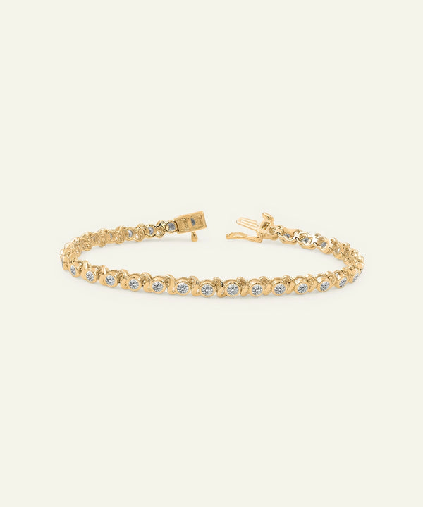 Gold bracelet with small stones on a light beige background