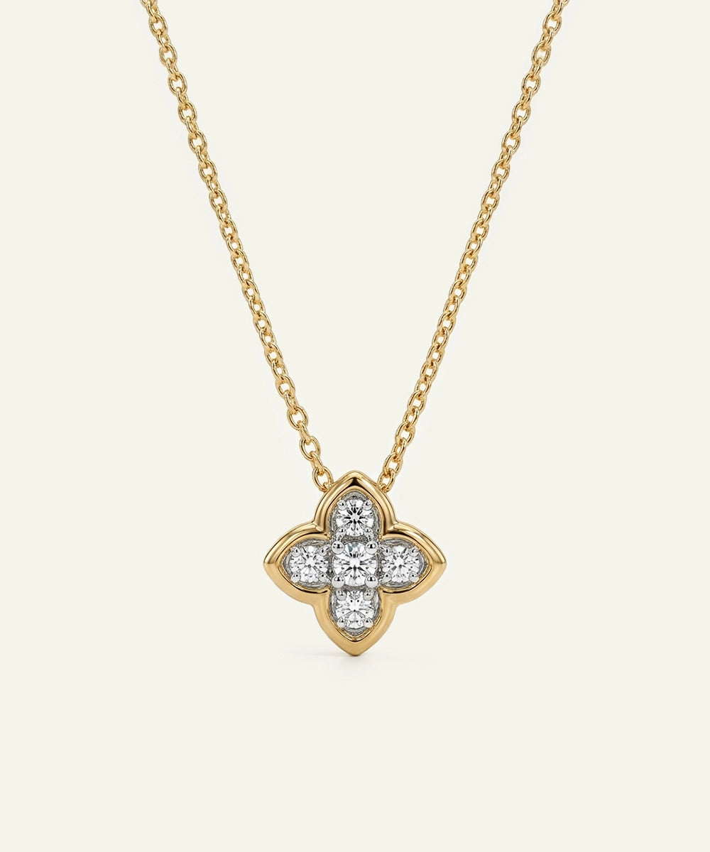 Gold necklace with a diamond quatrefoil pendant on a white background