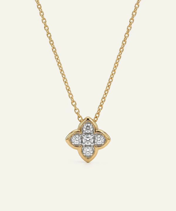 Gold necklace with a diamond quatrefoil pendant on a white background