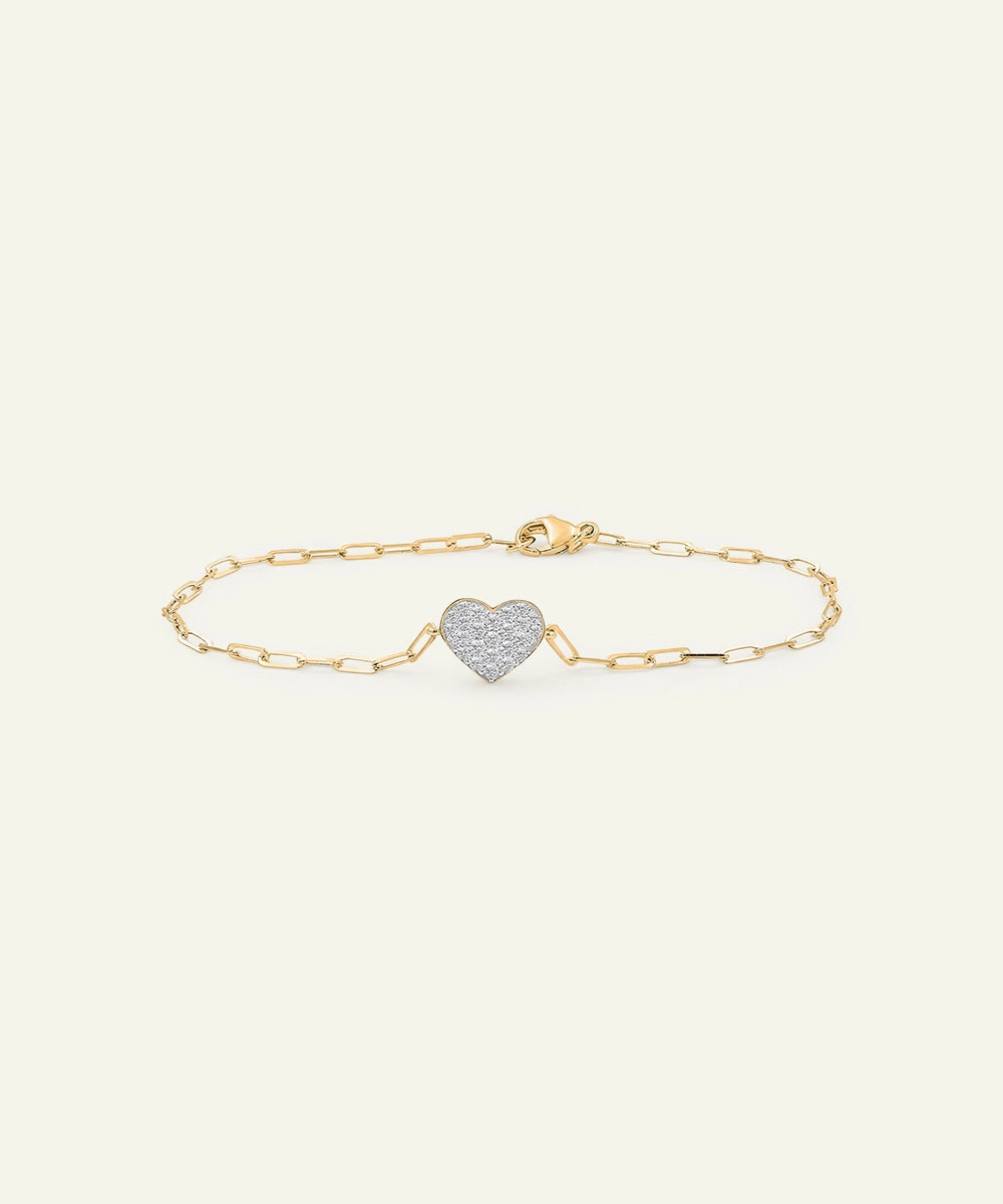 Gold bracelet with a heart-shaped charm on a white background