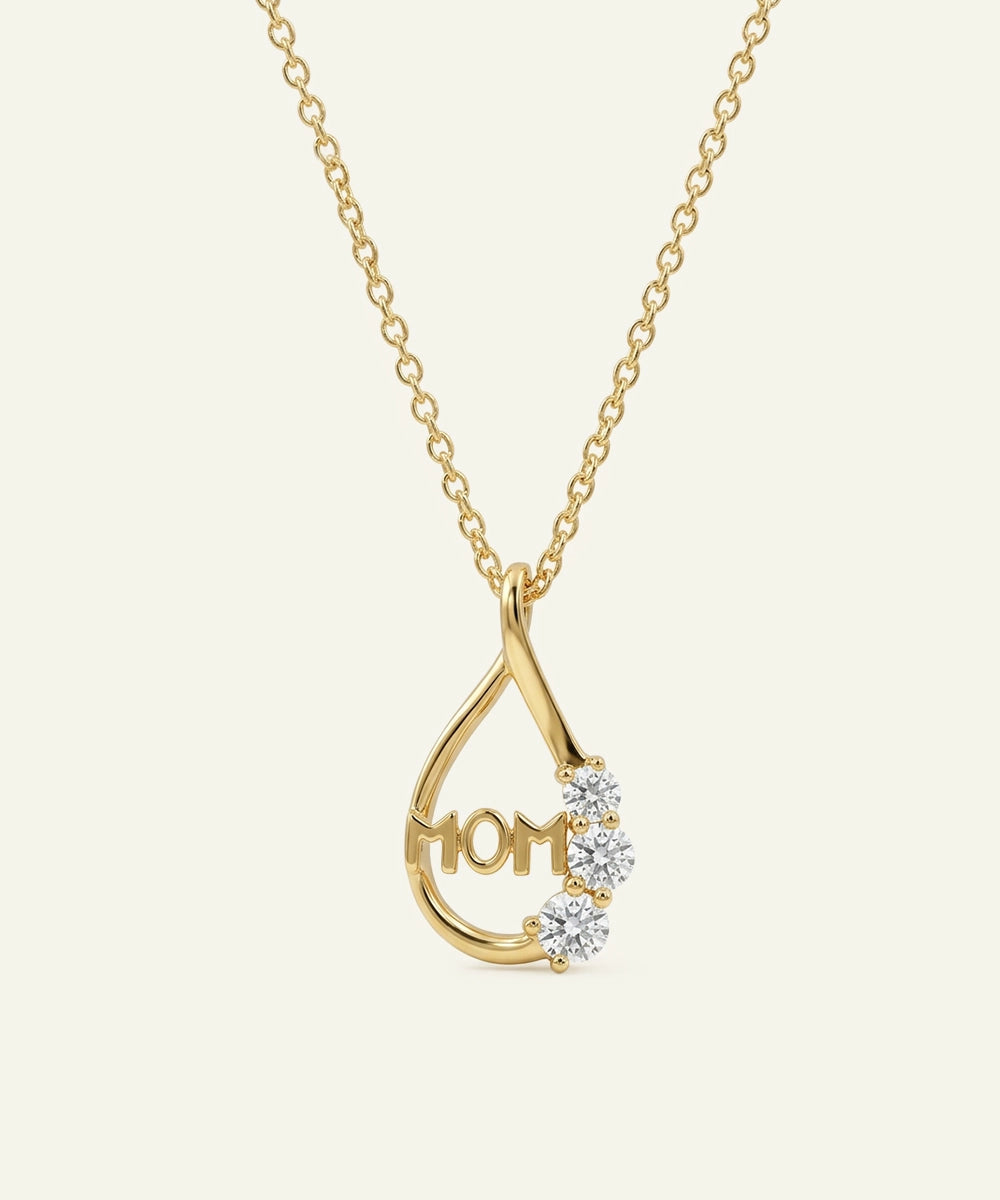 Gold necklace with 'MOM' pendant on a white background
