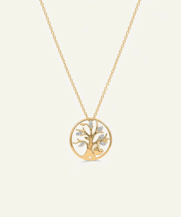 Gold tree-shaped pendant necklace on a light beige background