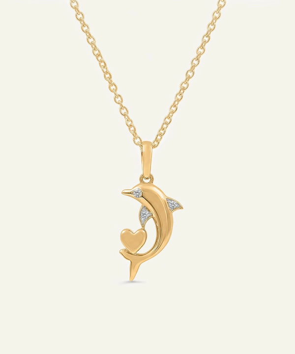 Gold necklace with a dolphin pendant on a light beige background