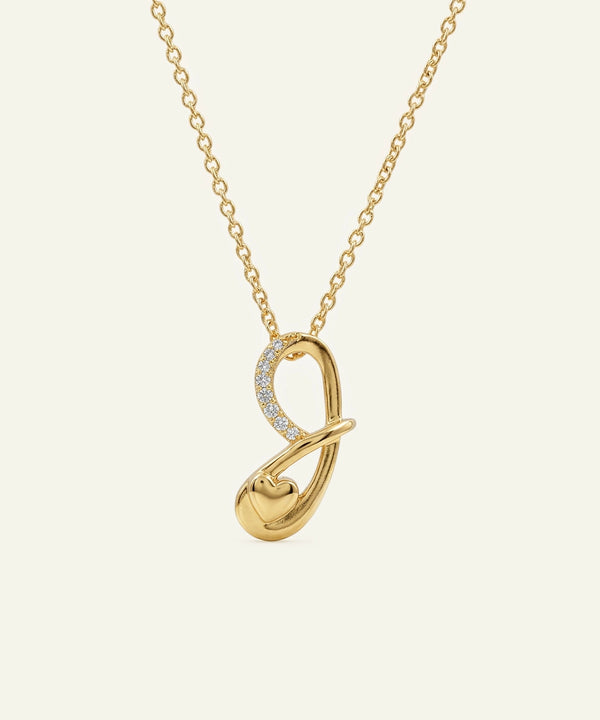 Gold necklace with a unique pendant on a light beige background